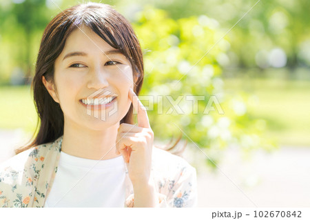 新緑の中で微笑む女性の写真 102670842