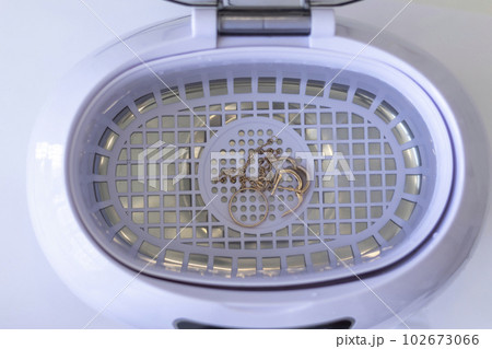 Washing gold, jewelry in an ultrasonic wash on a white background 102673066