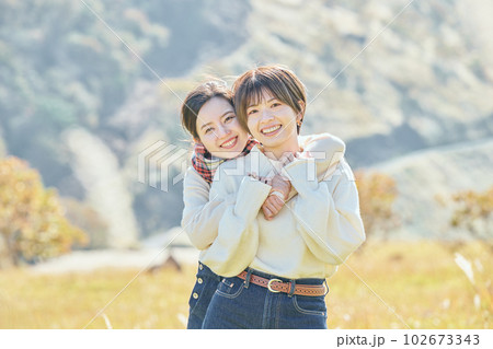 草原で後ろから抱きしめる若い女性と友達の写真素材 [102673343] - PIXTA