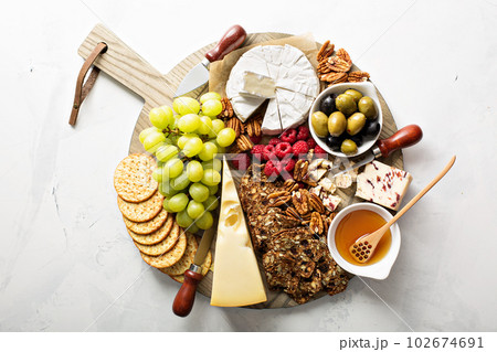 Cheese and snacks plate on white background Cheese and snacks plate on white background 102674691