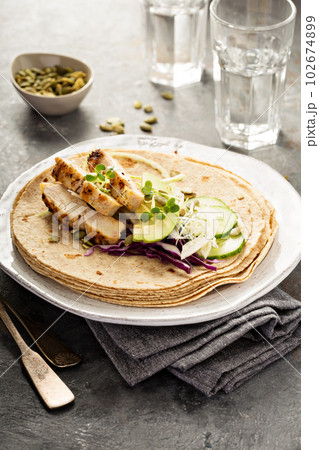 Making tacos with grilled chicken and avocado 102674899