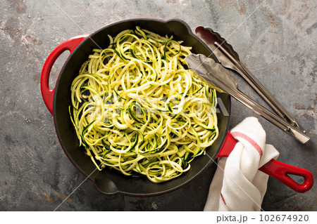Spiralized zucchini noodles in a cast iron pan Spiralized zucchini noodles in a cast iron pan 102674920