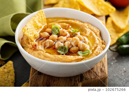 Homemade hummus in white bowl with corn chips Homemade hummus in white bowl with corn chips 102675266