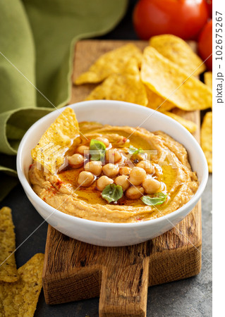 Homemade hummus in white bowl with corn chips Homemade hummus in white bowl with corn chips 102675267