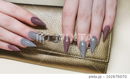 Manicure and nail extension with acrylic and gel. The design is made with reflective gel polishes. 102676070