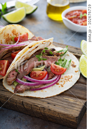 Steak tacos with sliced meet, salad and tomato salsa Steak tacos with sliced meet, salad and tomato salsa 102676719