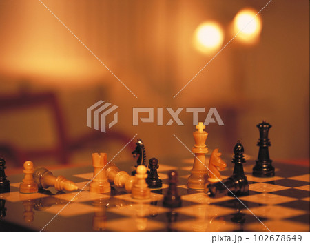 アンバーな照明の光を受けたチェス盤の駒たち 102678649