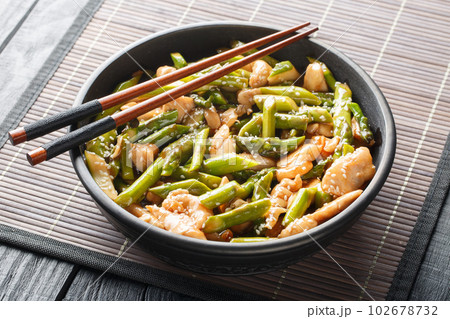 Fried chicken with asparagus and sesame close-up in a bowl. Horizontal 102678732