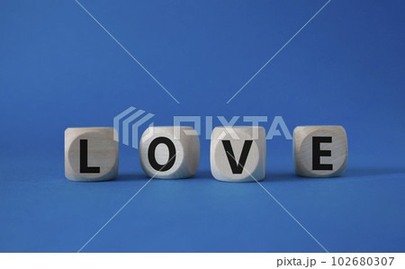Love symbol. Concept word Love on wooden cubes. Beautiful blue background. Business and Love concept. Copy space. Love symbol. Concept word Love on wooden cubes. Beautiful blue background. Business and Love concept. Copy space. 102680307
