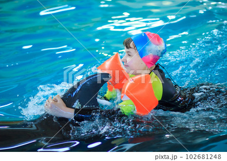 Happy little girl swimming with dolphins in Dolphinarium Happy little girl swimming with dolphins in Dolphinarium 102681248