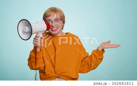 Woman talking with megaphone, proclaiming news, loudly announcing advertisement pointing empty place 102681811