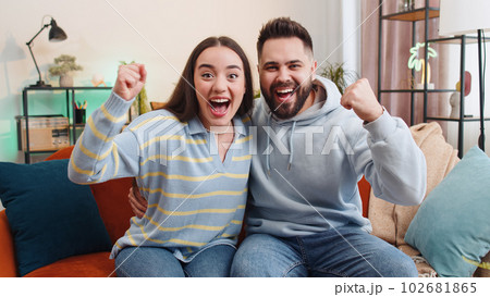 Excited family couple surprised, shocked by sudden victory, good win news, celebrating, wow reaction 102681865