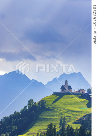 Mountainous landscape with villages of Colle Santa Lucia with church in Dolomites, South Tyrol, Italy Mountainous landscape with villages of Colle Santa Lucia with church in Dolomites, South Tyrol, Italy 102682581