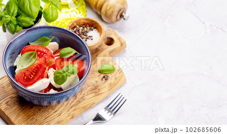 Caprese salad with ripe tomatoes, mozzarella cheese and garden basil Caprese salad with ripe tomatoes, mozzarella cheese and garden basil 102685606