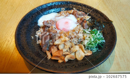 A Menu from a sushi restaurant "Beef Garlic Fried Rice with Onsen Egg" is onion fried rice with half-cooked beef and egg, very tasty. 102687575