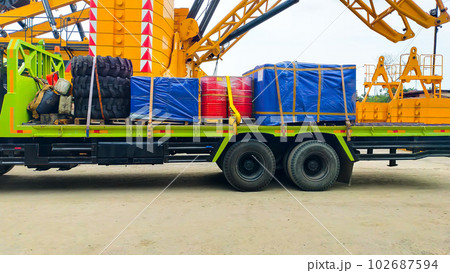 A cargo truck loaded with tire, drum and pallet boxes. 102687594