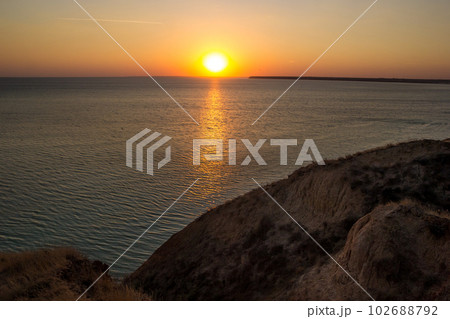 Setting Sun Reflecting on Water with Calm Ocean Waves 102688792