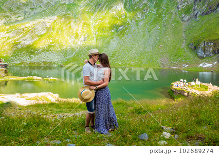A beautiful couple hugging near of Lake Balea in Romania A beautiful couple hugging near of Lake Balea in Romania 102689274