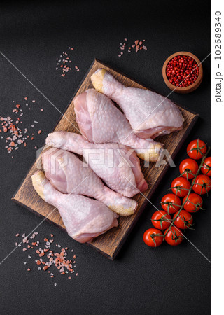 Raw chicken legs with salt, spices and herbs 102689340