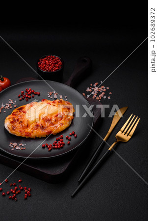 Grilled chicken fillet in the form of a steak with tomatoes, pineapple and cheese Grilled chicken fillet in the form of a steak with tomatoes, pineapple and cheese 102689372