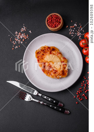 Grilled chicken fillet in the form of a steak with tomatoes, pineapple and cheese Grilled chicken fillet in the form of a steak with tomatoes, pineapple and cheese 102689398