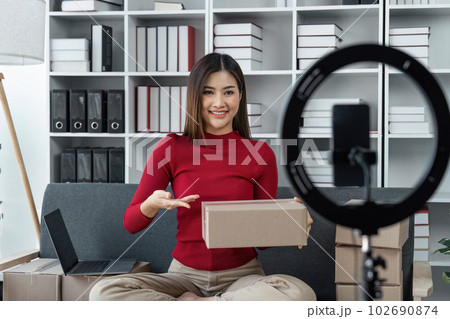 woman are going live selling products, selling products online, packing orders from customers who order through online selling sites. Concept of selling products online and e-commerce woman are going live selling products, selling products online, packing orders from customers who order through online selling sites. Concept of selling products online and e-commerce 102690874