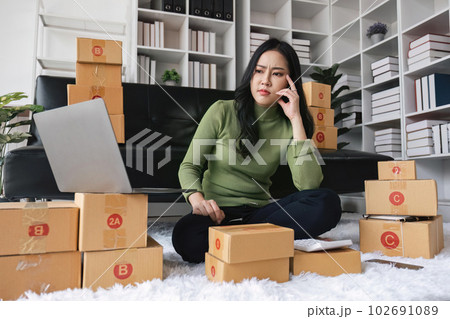 Young startup small business entrepreneur woman packing package post shipping box preparing delivery parcel , Online business, ecommerce and delivery concept. stressed headache 102691089