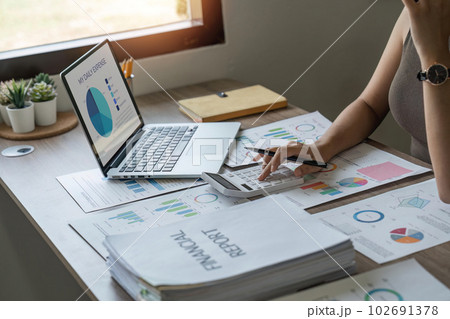 Close-up woman hand press calculator to calculate the company's financial results On the wooden table in the office and business work tax, accounting, statistics, and analytical research 102691378