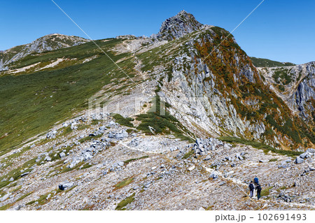 中央アルプス・極楽平付近の縦走路を行く登山者と宝剣岳・木曽駒ヶ岳の眺め 102691493