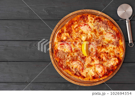 Tasty pizza on black wooden background top view Tasty pizza on black wooden background top view 102694354