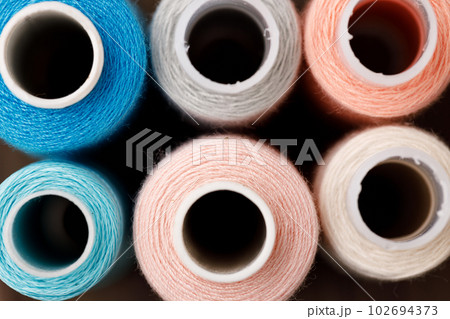 Close up of colored thread coils, thread spools background Close up of colored thread coils, thread spools background 102694373