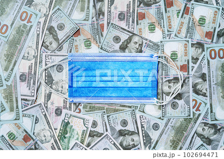 Medical mask on a background of US Dollar banknotes, top view 102694471
