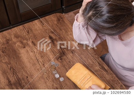 【長財布をみて頭を抱える主婦　長財布と小銭】 102694580