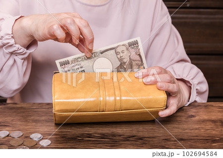 【長財布から10000円札を出す主婦　小銭有】 102694584