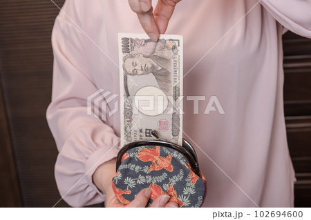 【がま口から10000円札を出す主婦】 【がま口から10000円札を出す主婦】 102694600