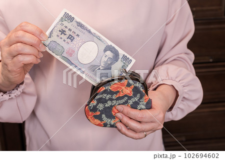 【がま口から1000円札を出す主婦】 【がま口から1000円札を出す主婦】 102694602