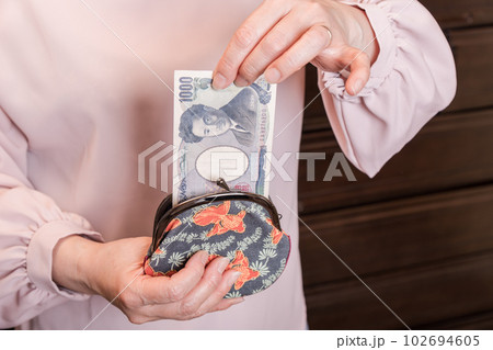 【がま口から1000円札を出す主婦】 102694605