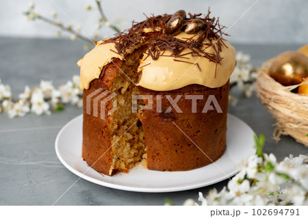 Cut Easter cake on plate decorated with spring flower branches 102694791