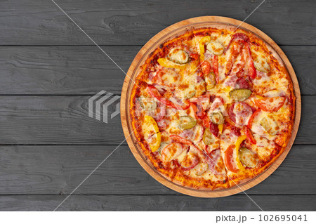 Top view of hot pizza on black wooden table 102695041
