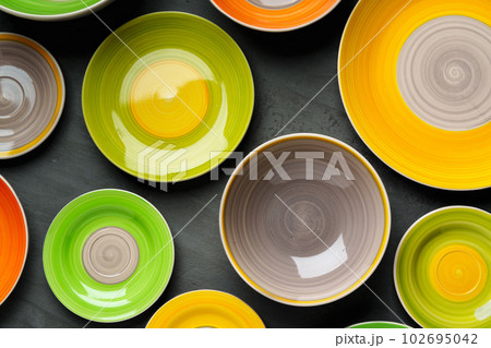 Color ceramic plates on gray background top view 102695042