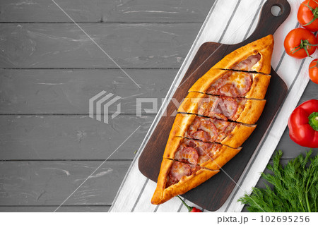 Turkish stuffed flatbread pide on gray wooden table 102695256