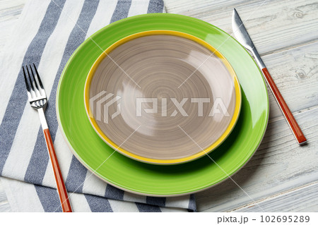Top view of color ceramic plate on wooden background 102695289