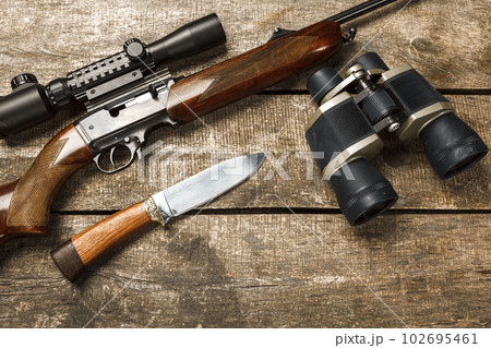 Hunting rifle and binoculars on dark wooden background 102695461