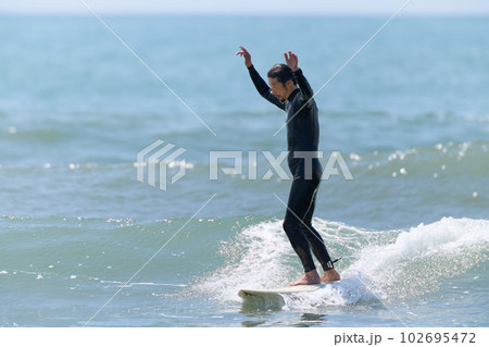 サーフボードに乗って両手を挙げる男性 サーフボードに乗って両手を挙げる男性 102695472