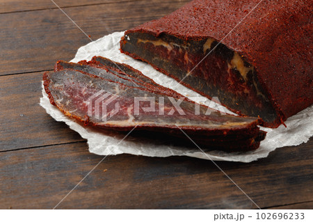 Sliced basturma meat on brow wooden background 102696233
