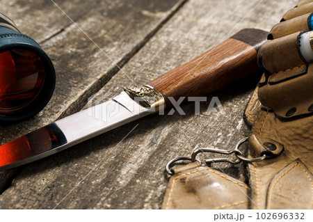 Various hunting equipment on old wooden background Various hunting equipment on old wooden background 102696332