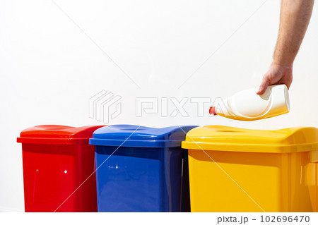 A man throws garbage into the trash can close up 102696470