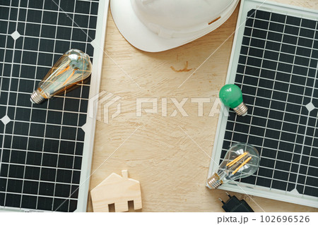 Wooden house miniature and solar panel close up Wooden house miniature and solar panel close up 102696526