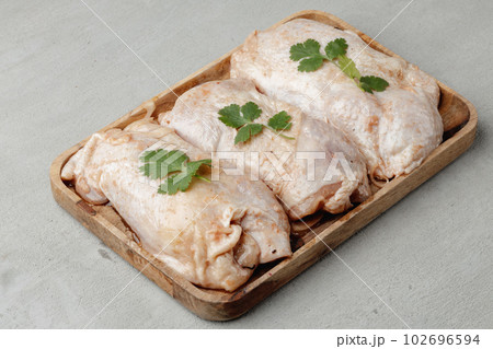 Raw chicken carcass on wooden plate close up Raw chicken carcass on wooden plate close up 102696594