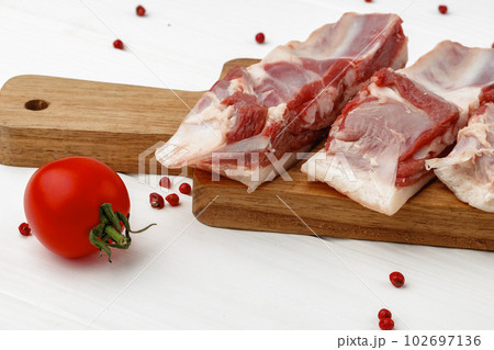 Raw meat ribs on wooden board on white background Raw meat ribs on wooden board on white background 102697136